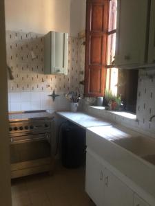 a kitchen with a stove and a sink and a window at La villetta Blue in Palermo