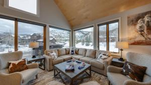 sala de estar con sofá, sillas y ventanas en Chalet Memoire en Steamboat Springs