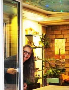 a woman is smiling in a room with a window at Eva Und Wolf Apartments in Sachsenheim