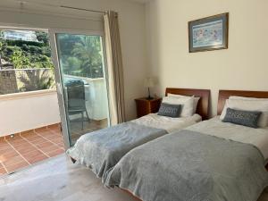 una camera con 2 letti e una porta scorrevole in vetro di 5-Bed Villa Mijas La Cala Golf & Spa Resort a Mijas