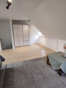 an empty living room with a table and white cabinets at Haus im Erholungsgebiet Detern in Detern +3 photos