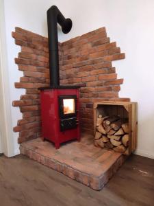 a brick oven with a pile of fire wood at Haus im Erholungsgebiet Detern in Detern