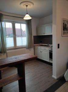 a kitchen with a wooden table in a room at Haus im Erholungsgebiet Detern in Detern