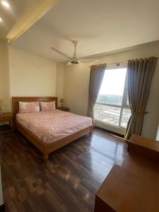 a bedroom with a bed and a large window at Luxury Apartment with Panoramic City Views in Islamabad