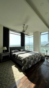 een slaapkamer met een bed en uitzicht op de oceaan bij Luxury Apartment with Panoramic City Views in Islamabad