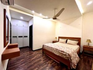 a bedroom with a bed and a ceiling fan at Luxury Apartment with Panoramic City Views in Islamabad