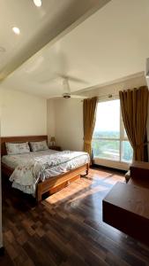 a bedroom with a large bed and a large window at Luxury Apartment with Panoramic City Views in Islamabad