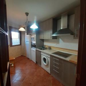 a kitchen with a washer and dryer in it at EL VIEJO OLMO in Herguijuela de la Sierra