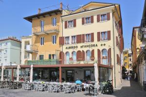 un bâtiment avec des tables et des chaises devant lui dans l'établissement Albergo All'Ancora, à Garde