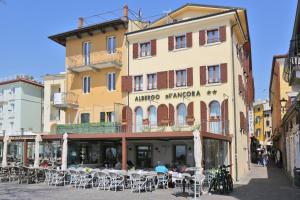 un edificio con mesas y sillas delante de él en Albergo All'Ancora, en Garda