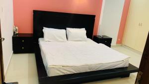un lit avec une tête de lit noire dans une chambre dans l'établissement Serene Home Apartment, à Islamabad