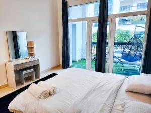 a bedroom with a large bed with two towels on it at Harf-G13 Fancy 1BR w big balcony at Ansam , Yas Island in Abu Dhabi