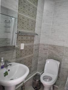 a bathroom with a white toilet and a sink at hotel Tourist in Karakol
