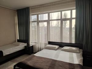 a bedroom with two beds and a large window at hotel Tourist in Karakol