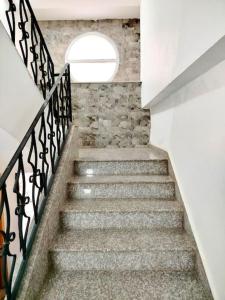 un escalier avec un mur en pierre et une fenêtre dans l'établissement Résidence Inaya, à Oran