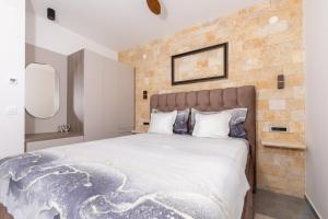um quarto com uma cama grande e uma parede de tijolos em Villa Vista em Jelsa