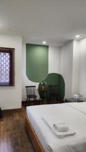a bedroom with a bed and a table with chairs at Lacovy Home Hội An in Hoi An