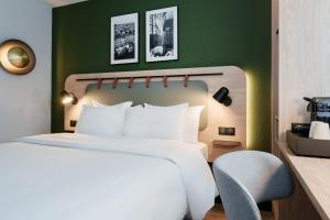 巴黎的住宿－鐘樓巴黎19維耶特酒店，卧室配有白色的床和椅子