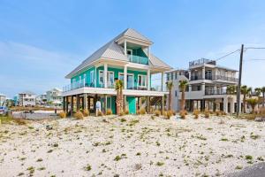 a house on the beach with palm trees in front of it at Nonni 'N Poppy's in Navarre
