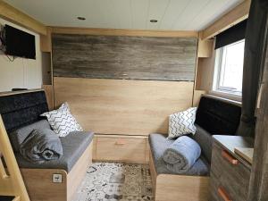 a small room with two couches in a tiny house at Pods 1 and 2 Willow Bank in Market Rasen