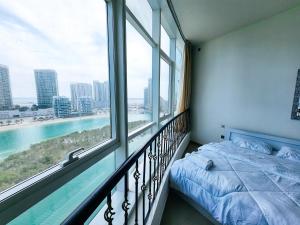 ein Schlafzimmer mit einem Bett und einem großen Fenster in der Unterkunft Comfy Studio with Stunning Vista, Pool and Gym in Abu Dhabi