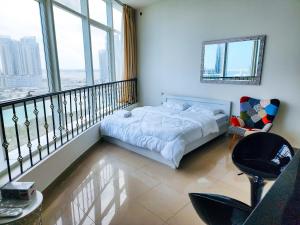a bedroom with a bed and a balcony with a view at Comfy Studio with Stunning Vista, Pool and Gym in Abu Dhabi