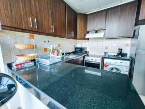 a kitchen with a counter top and a dishwasher at Comfy Studio with Stunning Vista, Pool and Gym in Abu Dhabi
