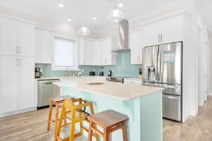 a kitchen with white cabinets and a blue island with stools at Nonni 'N Poppy's in Navarre