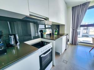a kitchen with a stove and a counter top at Harf3502 Luxurious Large Studio in Abu Dhabi