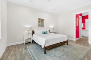 a white bedroom with a bed and a red door at Nonni 'N Poppy's in Navarre