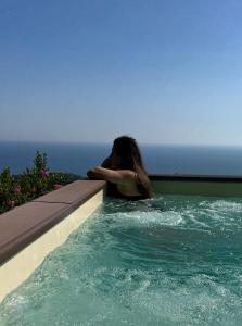 una mujer en una piscina cerca del océano en Villa Russo Casa Vacanze en Marina di Camerota