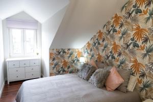 een slaapkamer met een bed met bloemenbehang bij Coqueto apartamento ideal para parejas in Muriedas