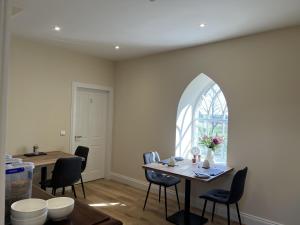 a dining room with a table and chairs and a window at Grainbank Mews in Kirkwall