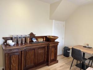 un armario de madera en una habitación con mesa en Grainbank Mews en Kirkwall