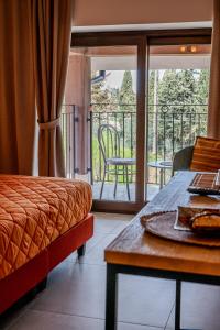 Cette chambre comprend un lit, une table et un balcon. dans l'établissement AgriBio Villa Ribes, à Altamura