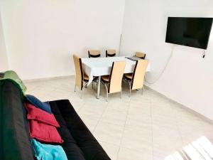 - une salle à manger avec une table, des chaises et une télévision dans l'établissement Résidence Inaya, à Oran