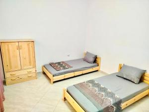 Cette chambre comprend 2 lits et une commode. dans l'établissement Résidence Inaya, à Oran