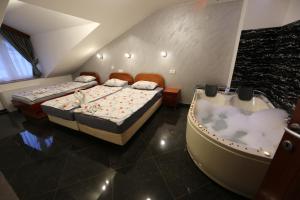 two beds in a room with a bath tub at Villa Maki in Ohrid