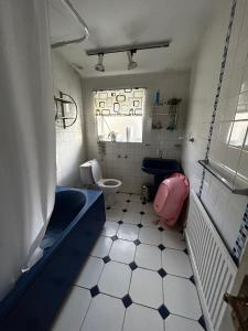 a bathroom with a tub and a toilet and a sink at Waltham Cross Rooms in Cheshunt