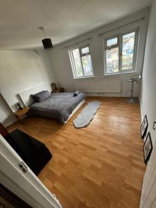 a bedroom with a bed and a wooden floor at Waltham Cross Rooms in Cheshunt