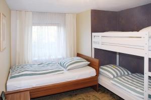 a bedroom with two bunk beds and a window at Wendelin`s Ferienwohnung in Wolfegg