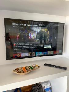 a flat screen tv sitting on a shelf at Le Rêve, les pieds dans l'eau, face à l'Ile de Ré in La Tranche-sur-Mer