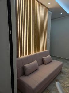 a couch in a room with a large window at AGORA luxury APARTMENT 10 in Loutraki +11 photos