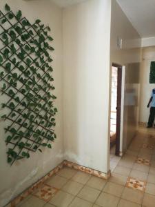une chambre avec une plante sur le mur dans l'établissement Mona Lisa Guest House, Kisumu, à Kisumu
