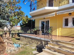 una casa gialla con balcone e scale di Villa Teodora 