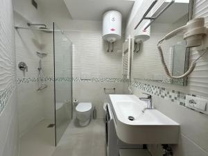a white bathroom with a sink and a toilet at Le Ghiaie Relax in Portoferraio +28 photos