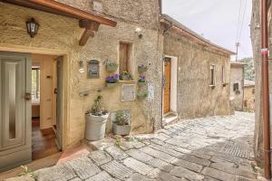 un edificio de piedra con macetas en la pared en Appartamenti Anguria Toscana, en Sinalunga