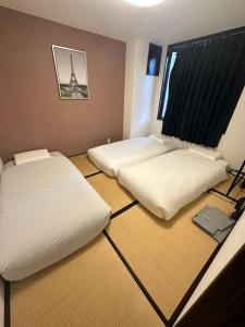 2 camas en una habitación con la torre Eiffel en GEGE house en Osaka