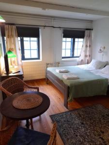 a bedroom with a bed and a table and two windows at Wiikki Majatalo in Viitasaari +5 photos