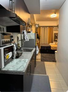 cocina con fregadero y habitación con cama en Flexi-Living Premium Condo in Kasara en Manila